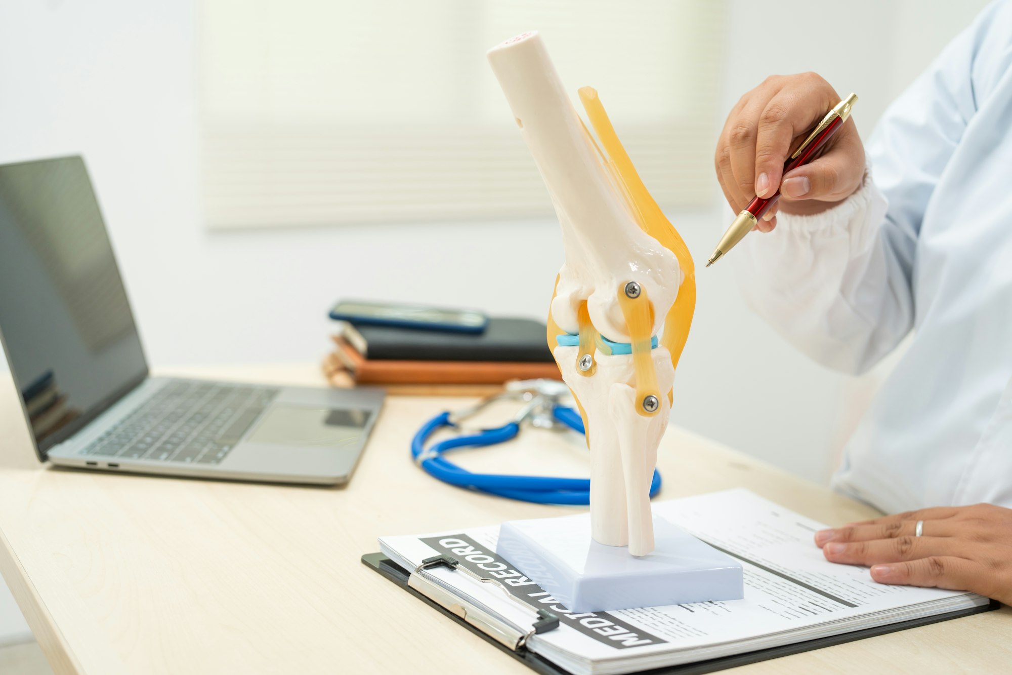 A female doctor works at desk in the hospital, discussing bone joint diseases like osteoarthritis,