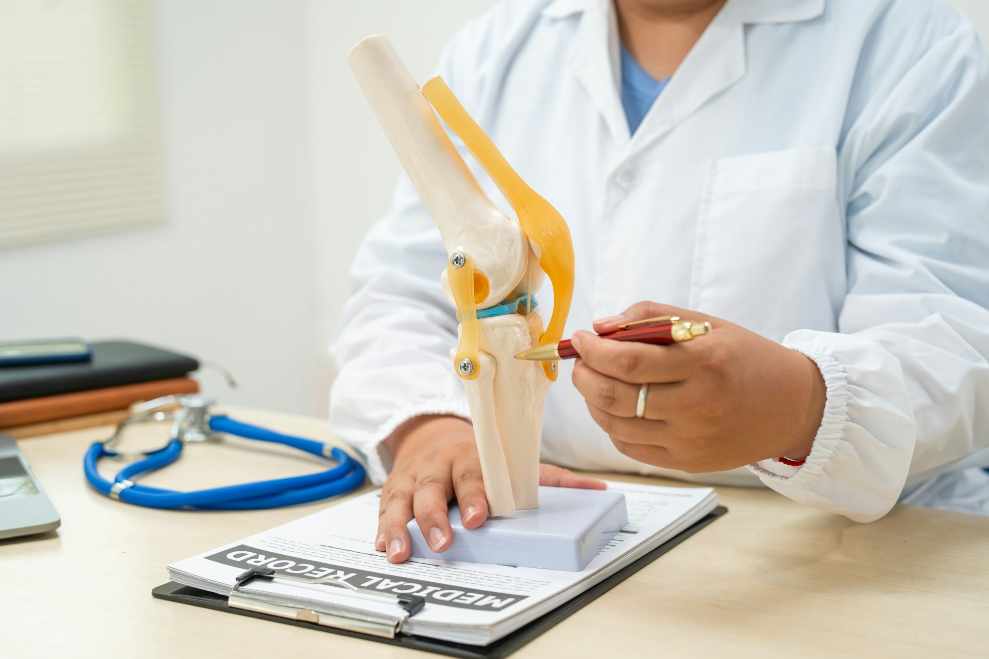 A female doctor works at desk in the hospital, discussing bone joint diseases like osteoarthritis,