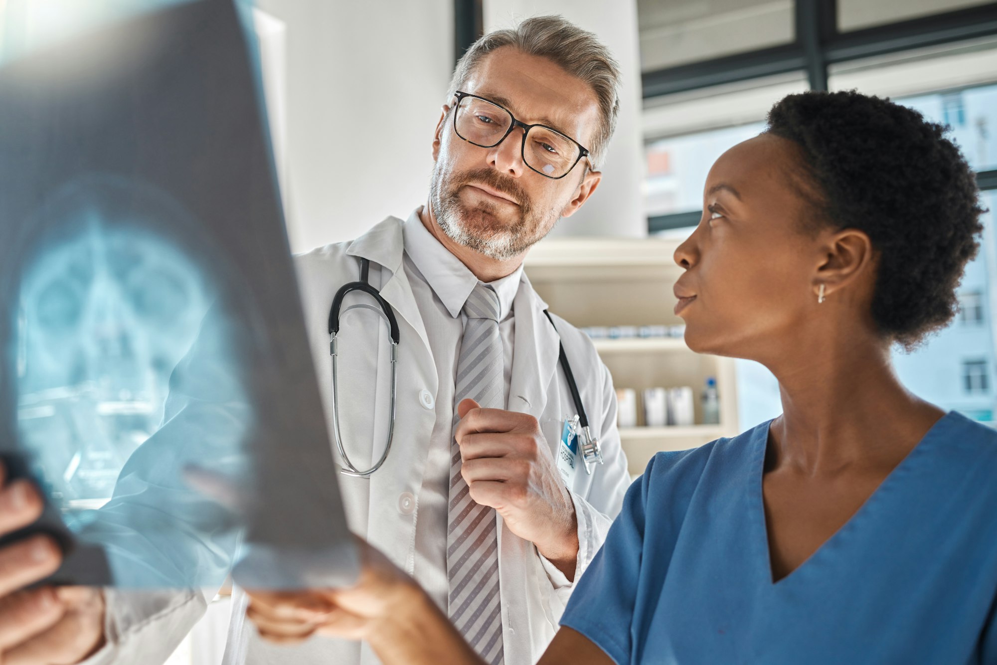 Brain, x ray and neurology doctors in a meeting working on a skull injury in emergency room in a ho