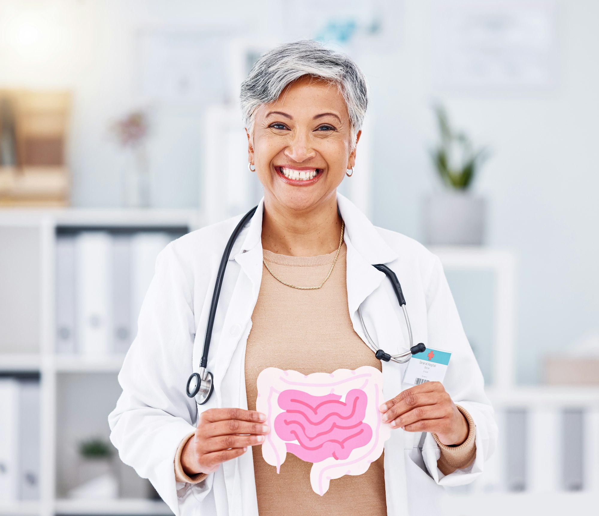 Portrait, doctor and mature woman with intestine model in hospital clinic. Face, gastroenterology a