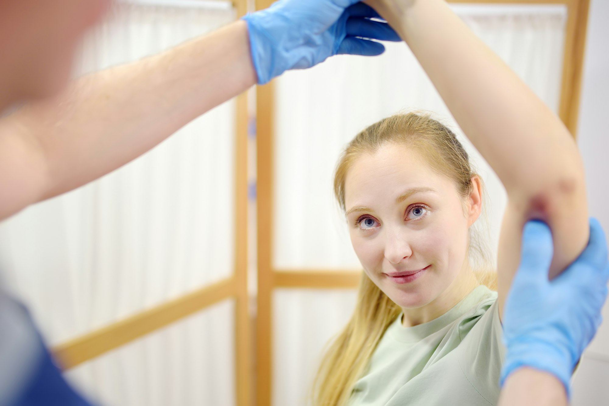 Young woman at an appointment with rheumatologist talks about pain symptom and bruises